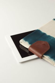 an ipad case is sitting on top of a white tabletop with a blue and green tie dye design