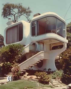 an unusual house sits on top of a hill in front of some trees and bushes