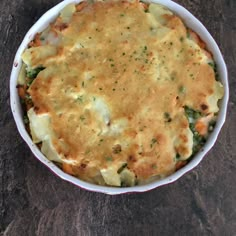 a casserole dish with cheese and broccoli in it on a table