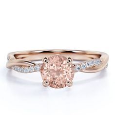 a pink diamond engagement ring with white diamonds on the band and a rose cut stone in the center