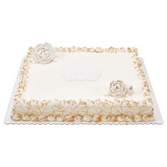 a square cake with white frosting and gold sprinkles on the edges