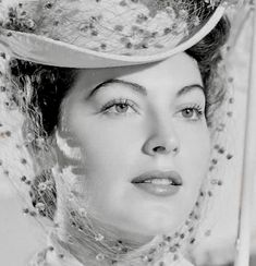 a black and white photo of a woman wearing a hat