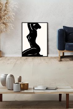 a black and white photo of a woman's body on a wall above a coffee table