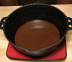 a pan filled with chocolate sitting on top of a red plate