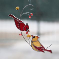 two stained glass birds perched on a branch