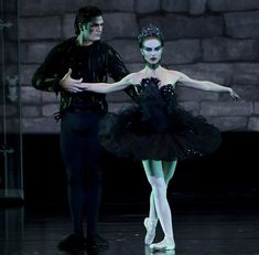 two ballerinas dressed in black and white are standing next to each other