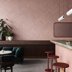 the interior of a restaurant with pink walls and bar stools