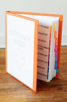 an emergency binder is open on a wooden table with the words emergency binder written in white