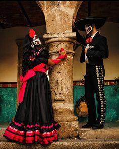 two people dressed up in costumes standing next to each other on the steps outside an old building