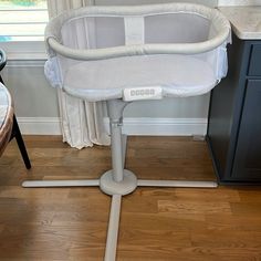 a baby crib sitting on top of a hard wood floor next to a window