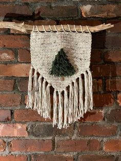 a wall hanging made out of woven material with a tree on it's side