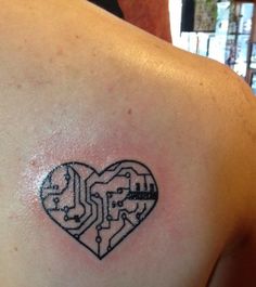 a heart shaped circuit board tattoo on the back of a man's shoulder