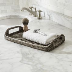 a bathroom with marble counter tops and white towels on the tray, next to a soap dispenser