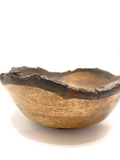 a wooden bowl sitting on top of a white table