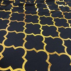 a black and gold table cloth with an intricate design on it's surface,