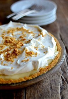 a pie with white frosting and crumbs sitting on top of a wooden table