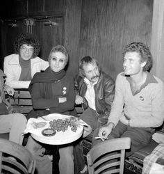 black and white photograph of people sitting around a table