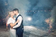 a man and woman kissing in front of fireworks