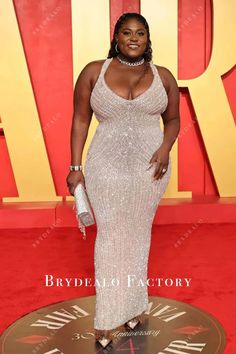 a woman in a white gown standing on a red carpet