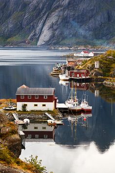 boats are docked in the water near houses and mountains