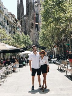 a man and woman standing in front of some buildings