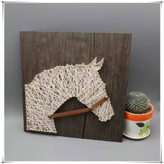 a wooden frame with a string horse head on it and a cactus in the background