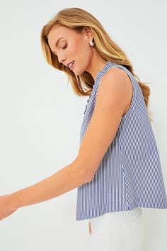 The Blue Striped Veronica Top is the elevated tank that you'll be reaching for all season long. Unfussy and feminine, this blouse features subtle ruffle detailing along the V-neckline for a bit of flirty flair while keeping it sophisticated. We are wearing this sleeveless stunner with denim, trousers, mini skirts (must we go on?) from work to play with ease and style. V-neckline Ruffle details on neckline Sleeveless Slightly curved hem Boxy silhouette Crisp lightweight fabric Material: 97% Cotto Chic Sleeveless Blouse With Ruffle Hem, Ruffled Straps Blouse With Ruffle Hem For Day Out, Chic Tops With Ruffled Straps For Day Out, Elegant Blue Tops With Ruffle Hem, Feminine Sleeveless Blue Blouse, Feminine Ruffle Hem Tank Top, Chic Blouse With Ruffled Straps For Day Out, Feminine Blouse With Ruffled Straps For Day Out, Chic Tops With Ruffle Hem And Ruffled Straps