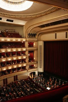 an auditorium filled with people sitting on the stage