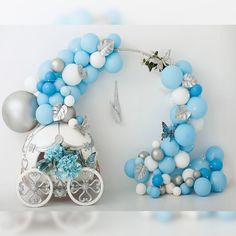 a blue and white balloon arch next to a baby carriage