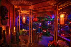 the inside of a hut with lights and plants