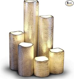 four gold colored candles are stacked on top of each other in the shape of cylinders