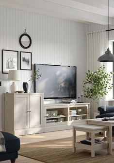 a living room filled with furniture and a flat screen tv on top of a wooden stand