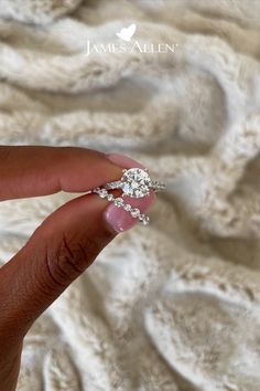 a woman's hand holding an engagement ring