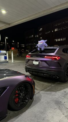 two cars parked in a parking lot at night