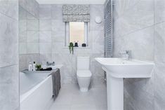 a bathroom with a sink, toilet and bathtub next to a wall mounted radiator