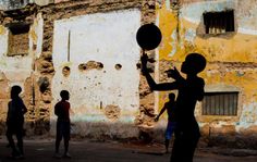 a group of children playing with a ball in the street