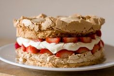 two desserts are stacked on top of each other with strawberries and whipped cream