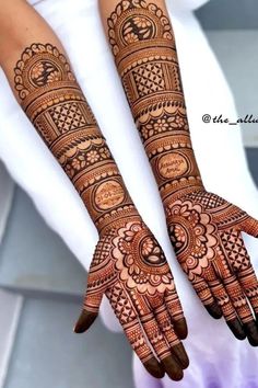 two hands with henna tattoos on them