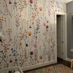 a bathroom with floral wallpaper and wooden flooring