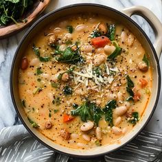 a bowl of white bean soup with spinach and parmesan cheese