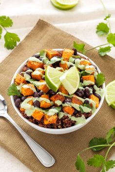 a white bowl filled with black beans, sweet potatoes and avocado garnish