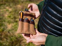 a person holding a leather pouch with two cigars in it