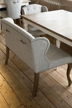 a dining room table with two chairs and a bench in front of it on a wooden floor