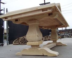 a wooden table sitting on top of a cement ground