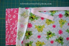 three pieces of fabric sitting next to each other on a green cutting mat with pink and white flowers