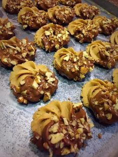 chocolate covered cookies with nuts on a baking sheet