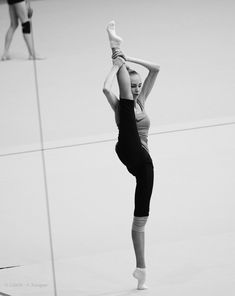 a woman is doing a handstand in the middle of a dance studio floor