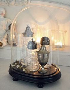 a snow globe with two silver vases under it