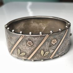 Victorian cuff bracelet in solid sterling silver .925 with green gold and rose gold accents. Hinged bracelet with UK assay marks from 1893. Decorated with romantic orange blossom flowers in rose gold with green gold leaves. Fits wrist size 6.5-8 inches. In beautiful condition! This is such a gorgeous well crafted piece! Total weight for the bracelet is a luxurious 24.5 grams. It is very well made and solid and is nice and sturdy for wear, in excellent condition.  If you would like to view additi Antique Jewelry Victorian, Flower Dark, Silver Aesthetic, Aesthetic Era, Buckle Jewelry, Victorian Bracelet, Jewelry Victorian, Georgian Jewelry, Forget Me Not Flower