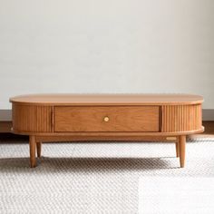 a wooden coffee table sitting on top of a carpeted floor next to a white wall